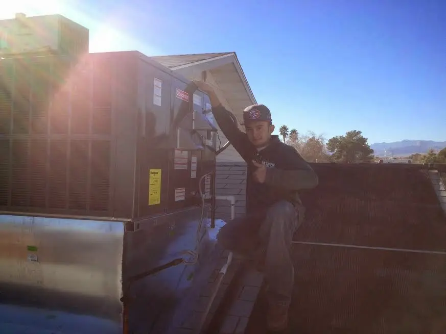 HVAC technician performing HVAC Inspection on a rooftop unit in Moapa Valley